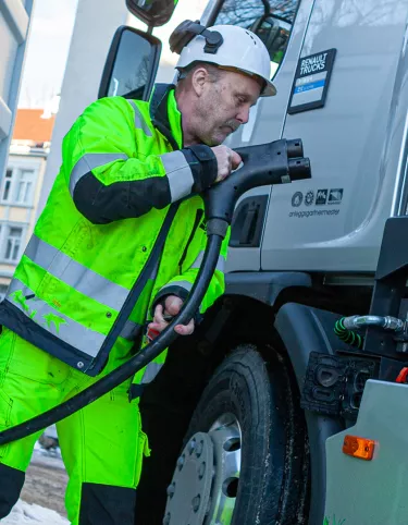Sjåfør kobler til ladekabel på elektrisk Renault lastebil